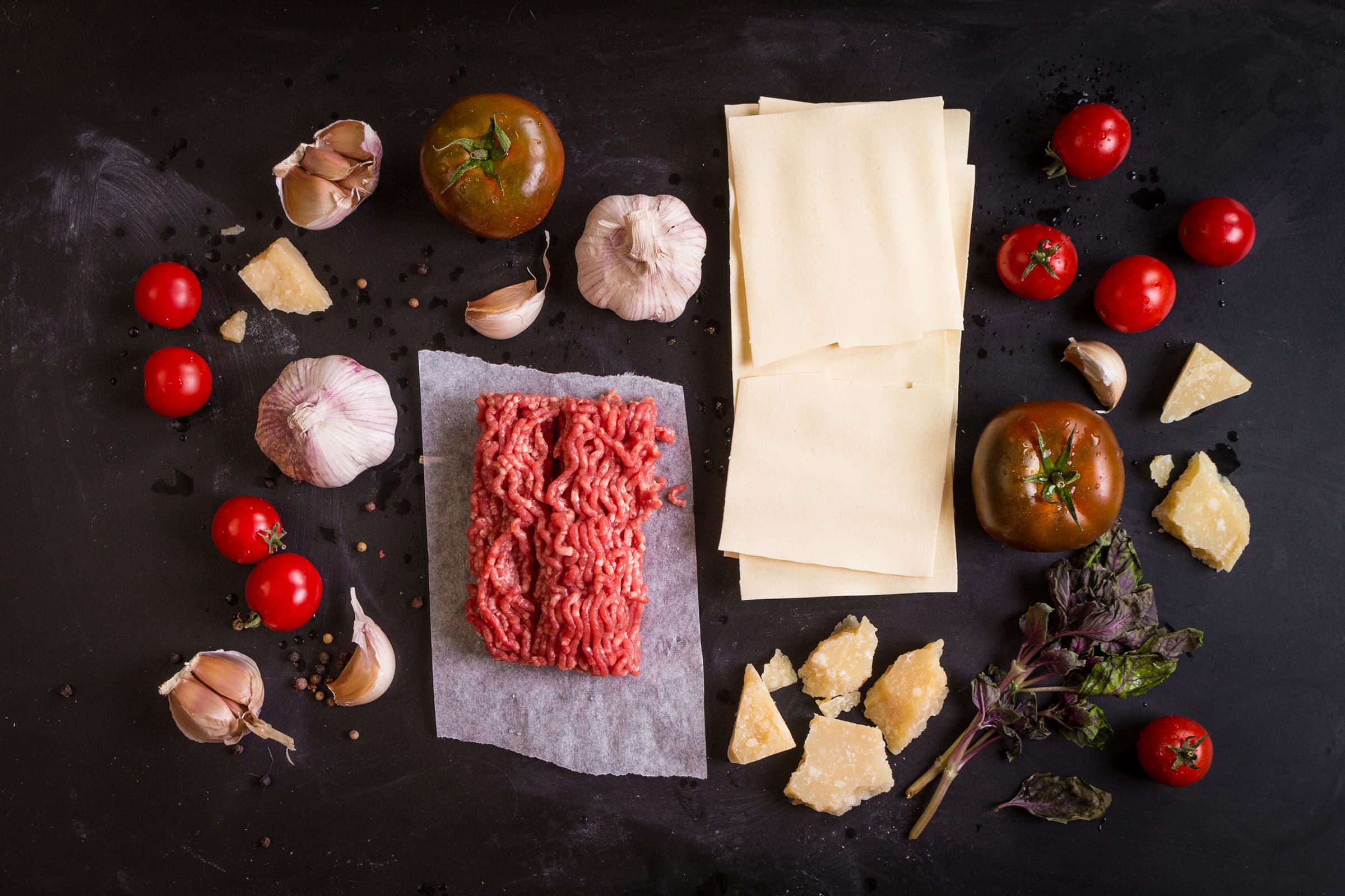 Top down image of some of the ingredients needed to make a beef lasagne recipe.